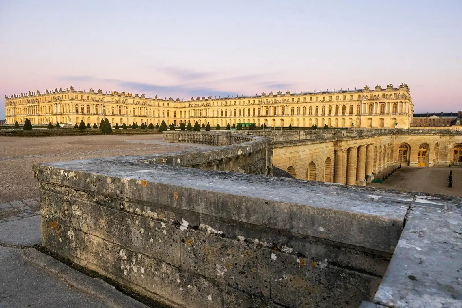 Façade dorée du Château de Versailles vue depuis les jardins à la française